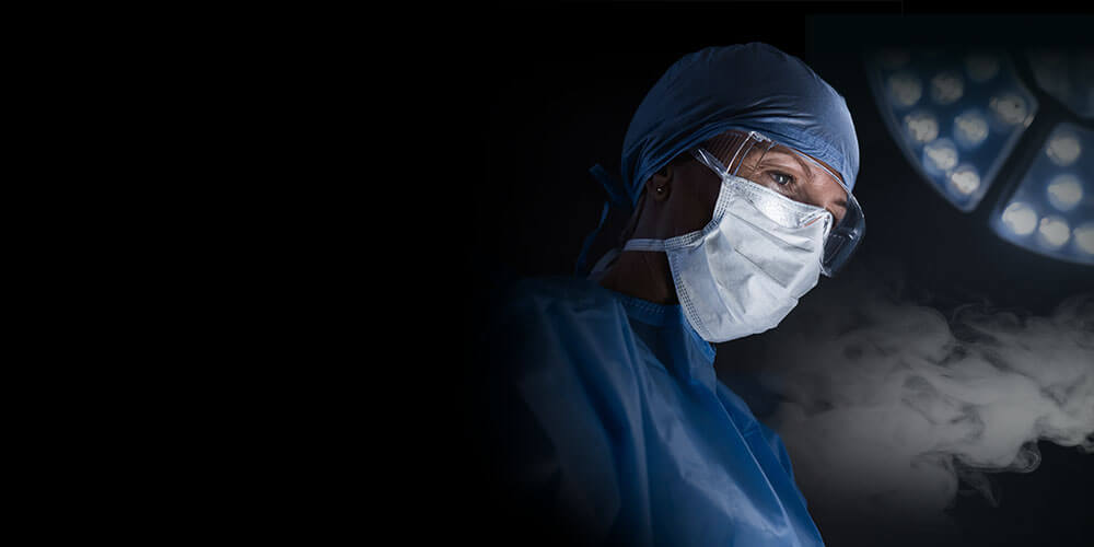 Woman surgeon surrounded in plume of smoke